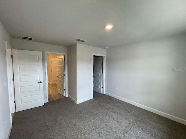 unfurnished bedroom featuring dark colored carpet