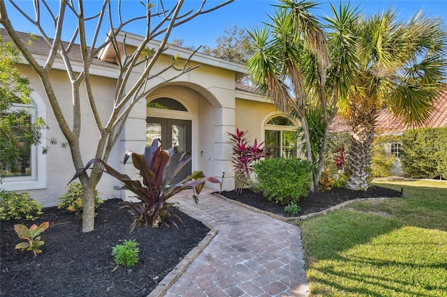 entrance to property with a yard and french doors