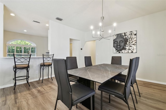 dining room featuring hardwood / wood-style flooring and a notable chandelier