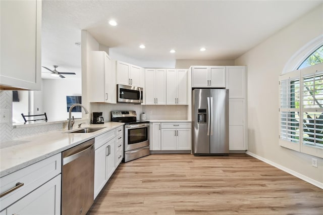 kitchen featuring tasteful backsplash, stainless steel appliances, sink, and white cabinets