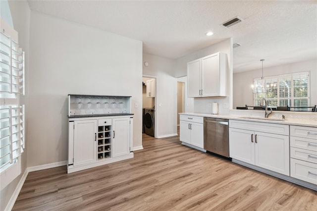 kitchen featuring dishwasher, sink, white cabinets, and decorative light fixtures