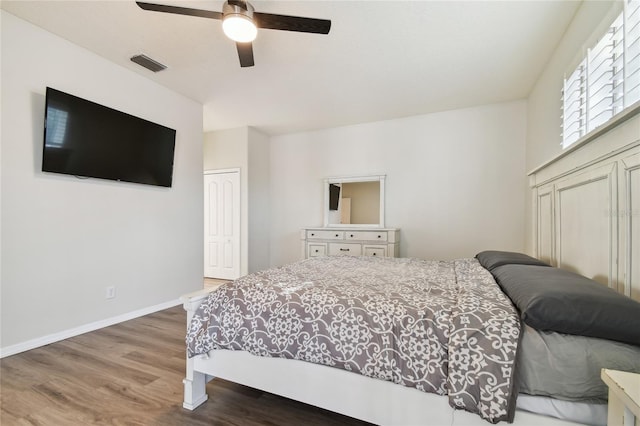 bedroom featuring ceiling fan, wood-type flooring, and a closet