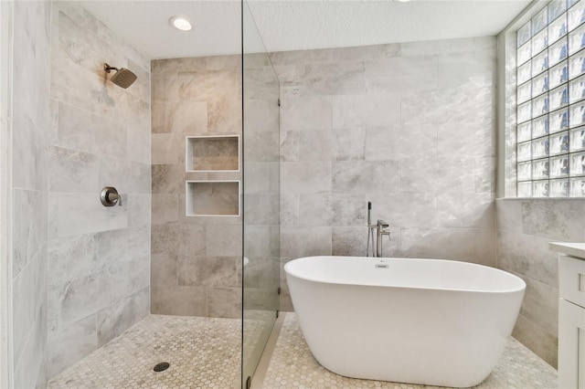 bathroom with vanity, independent shower and bath, and tile walls