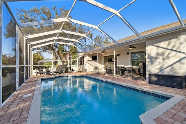 view of pool with ceiling fan, a patio, and glass enclosure