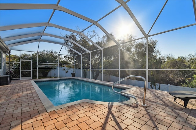 view of swimming pool with glass enclosure and a patio area