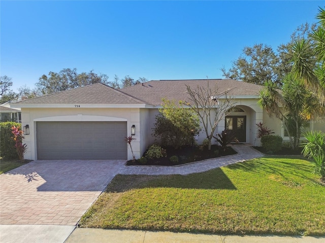 ranch-style house with french doors, a garage, and a front yard