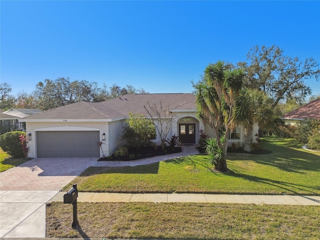 view of front of property with a garage and a front lawn