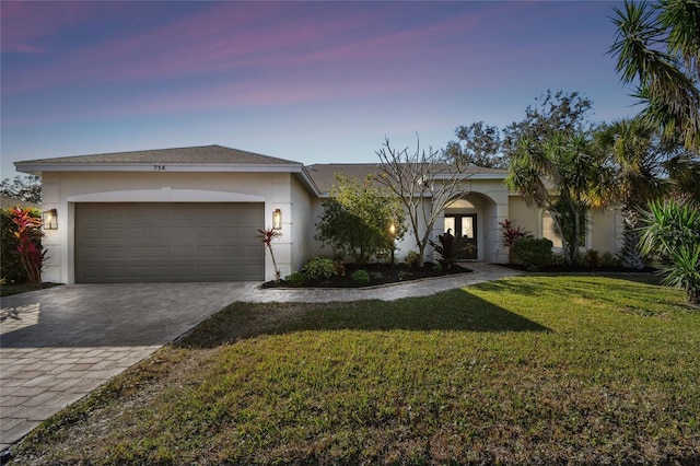 view of front of property featuring a garage and a lawn