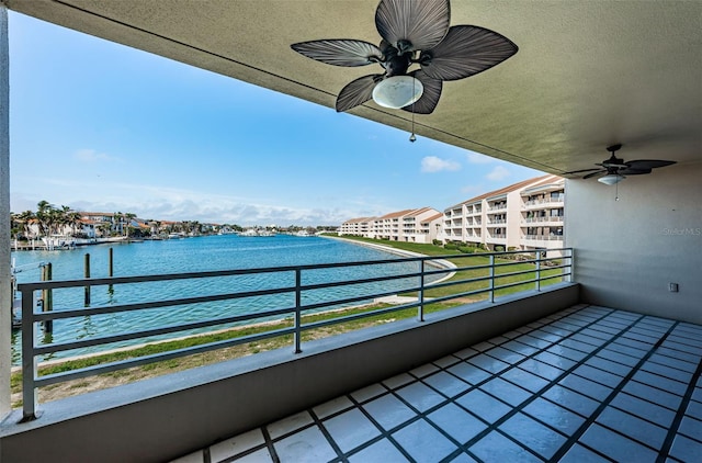 balcony featuring a water view and ceiling fan