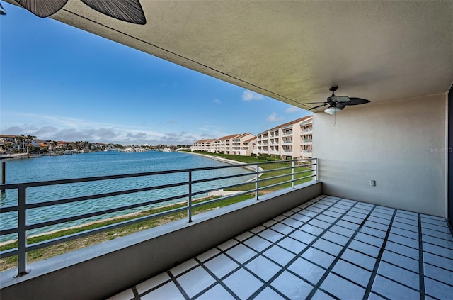 balcony featuring a water view and a ceiling fan