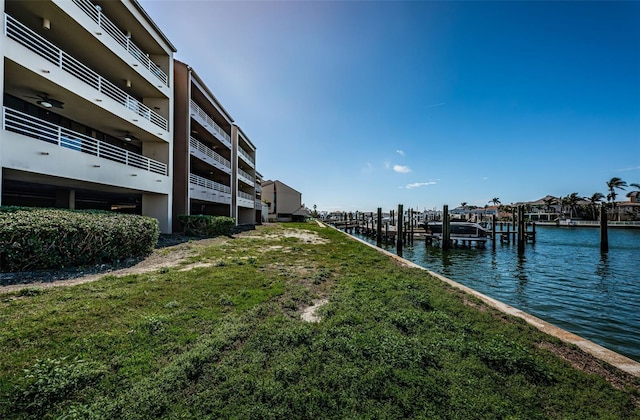 view of dock featuring a water view and a yard