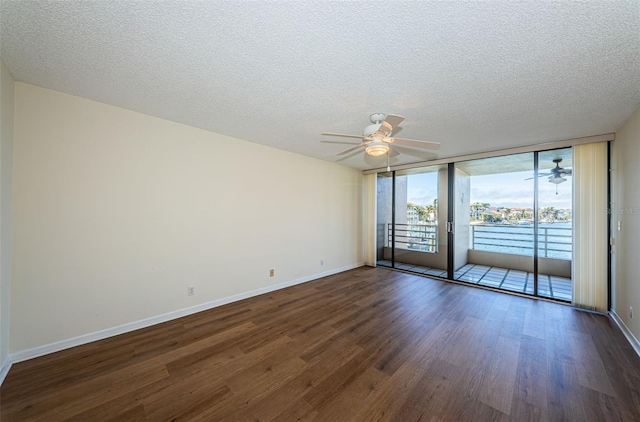 spare room featuring baseboards, floor to ceiling windows, dark wood finished floors, and a textured ceiling