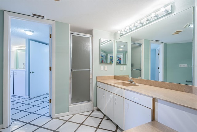 full bathroom with a textured ceiling, visible vents, vanity, tile patterned floors, and a stall shower