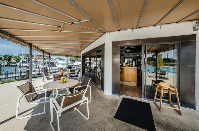 view of patio / terrace with a water view and fence