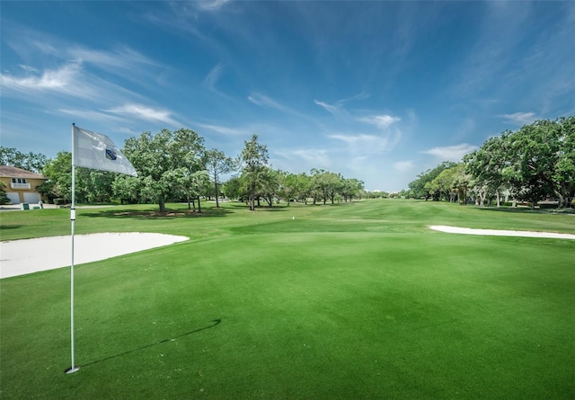 view of community with golf course view and a lawn