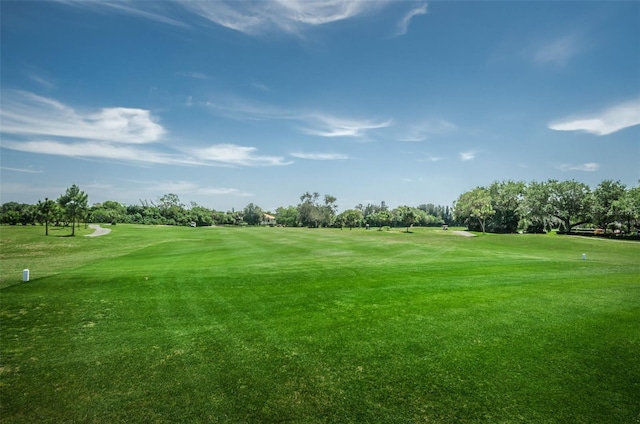 view of community with view of golf course and a yard