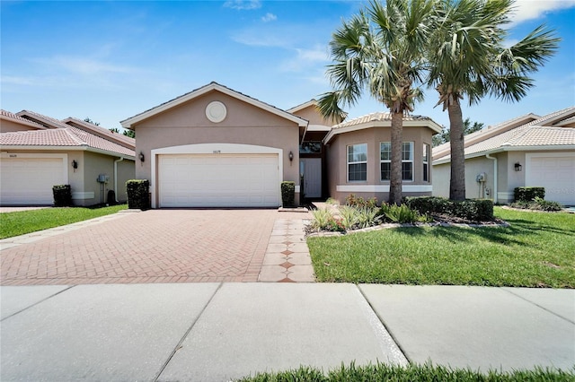 ranch-style home with a garage and a front lawn