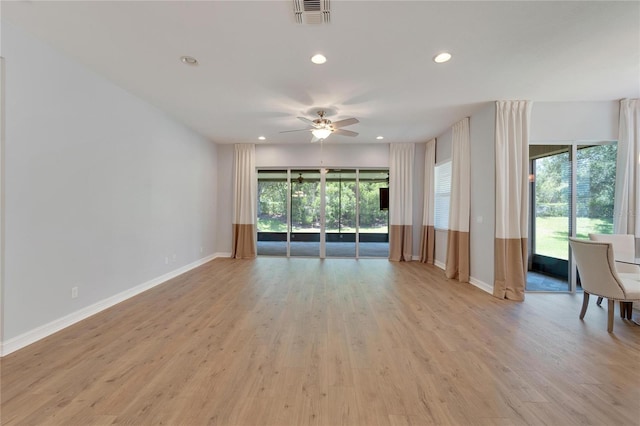 unfurnished living room featuring ceiling fan, light wood-type flooring, and a wealth of natural light