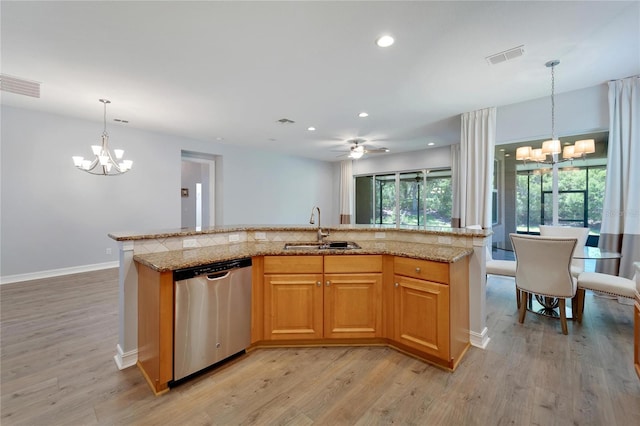 kitchen with pendant lighting, sink, a kitchen island with sink, stainless steel dishwasher, and light hardwood / wood-style flooring