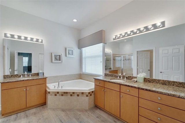 bathroom with vanity, wood-type flooring, and independent shower and bath