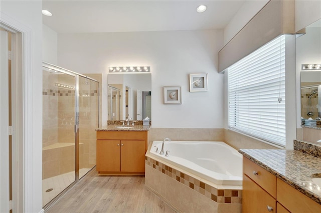 bathroom featuring vanity, wood-type flooring, and shower with separate bathtub