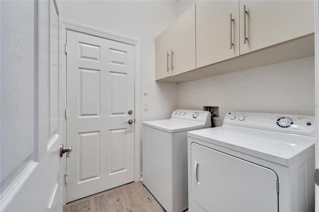 laundry area with cabinets, light hardwood / wood-style floors, and independent washer and dryer