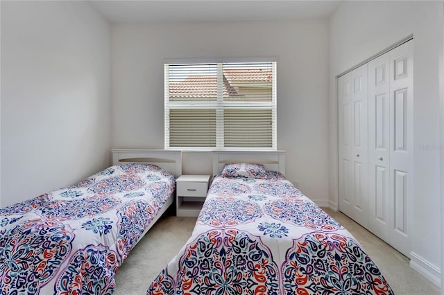 bedroom featuring light colored carpet and a closet