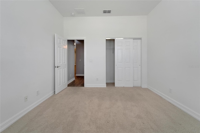 unfurnished bedroom featuring a closet and light carpet