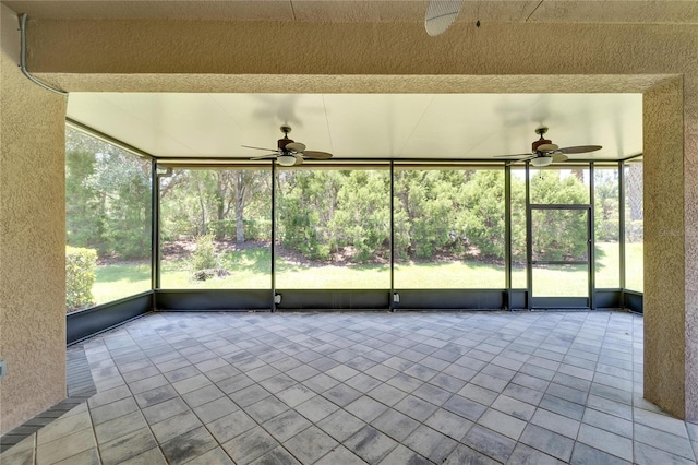 unfurnished sunroom featuring ceiling fan and plenty of natural light