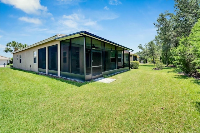 back of house featuring a sunroom and a lawn