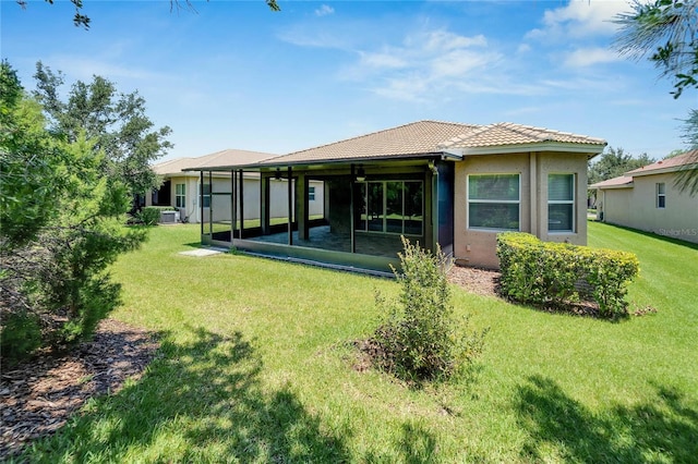 back of property with central AC and a lawn