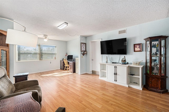 living room featuring light hardwood / wood-style flooring and a textured ceiling