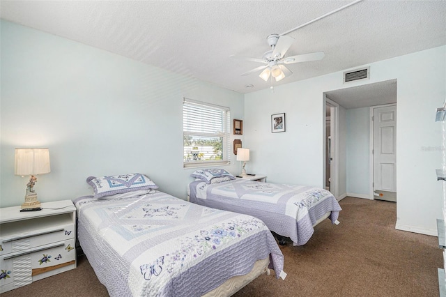 bedroom with ceiling fan, a textured ceiling, and dark colored carpet