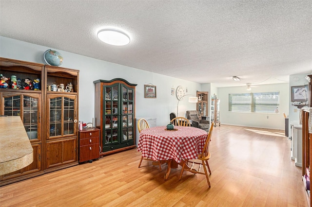 dining space featuring a textured ceiling and light hardwood / wood-style floors