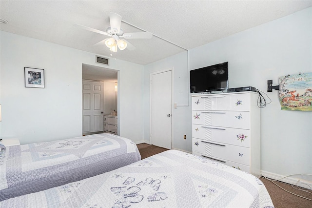 carpeted bedroom featuring ceiling fan and a textured ceiling