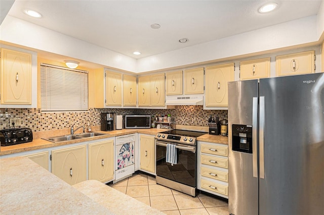 kitchen featuring stainless steel appliances, light tile patterned flooring, sink, and backsplash