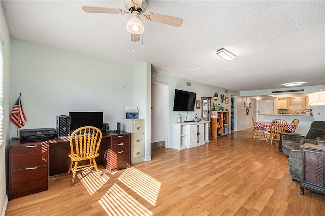 office featuring ceiling fan, light hardwood / wood-style flooring, and a textured ceiling