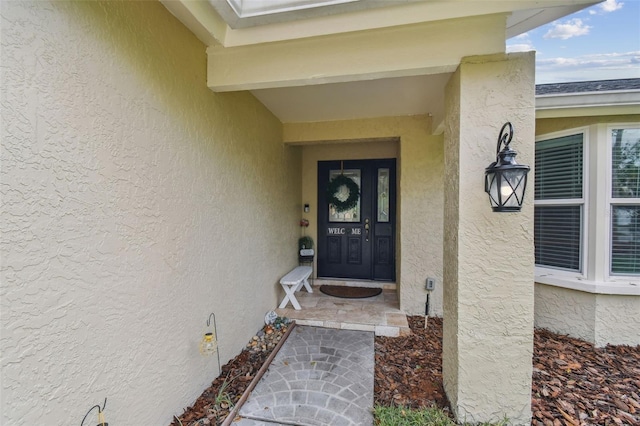 view of exterior entry featuring stucco siding