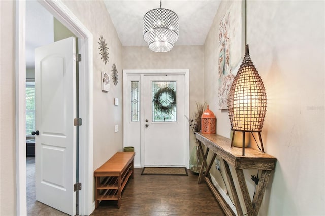 entryway featuring dark wood-type flooring, a healthy amount of sunlight, and an inviting chandelier