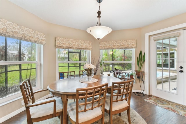 dining space with dark wood-type flooring and baseboards