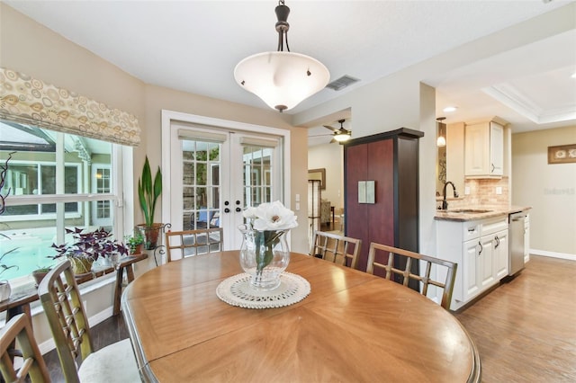 dining area featuring light wood-style floors, baseboards, visible vents, and french doors