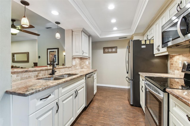 kitchen featuring light stone counters, a sink, white cabinetry, appliances with stainless steel finishes, and a raised ceiling