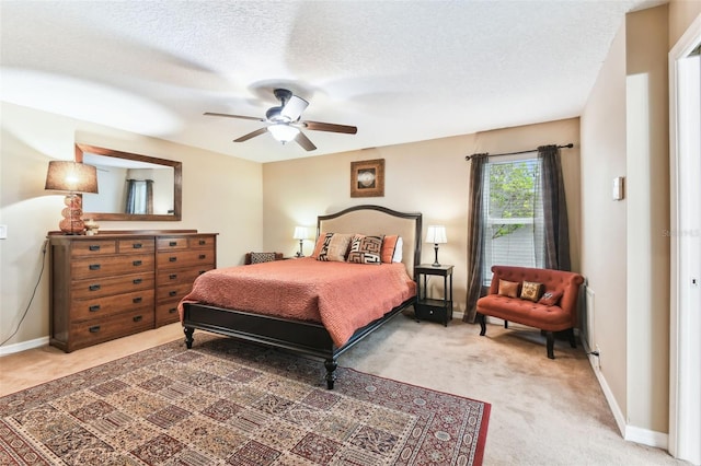 carpeted bedroom featuring ceiling fan, baseboards, and a textured ceiling