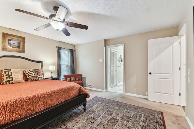 bedroom featuring light colored carpet, ceiling fan, a textured ceiling, and baseboards