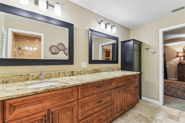 full bathroom with double vanity, visible vents, a shower, and a sink