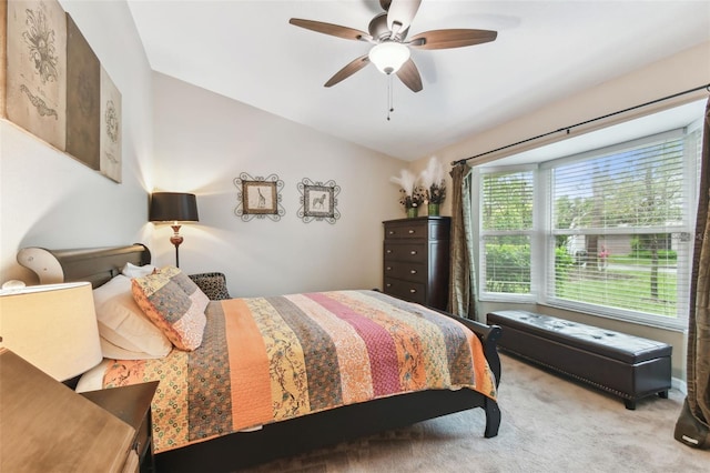 carpeted bedroom with ceiling fan and vaulted ceiling