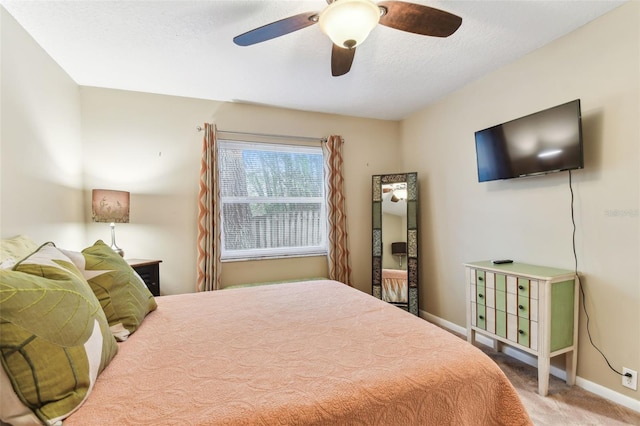 carpeted bedroom with a textured ceiling, ceiling fan, and baseboards