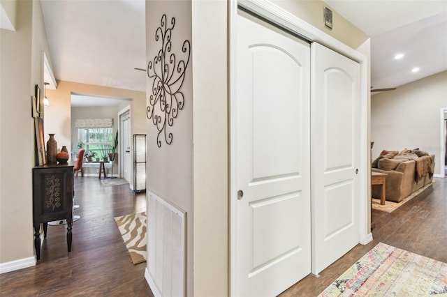 hallway featuring dark wood-type flooring, recessed lighting, visible vents, and baseboards