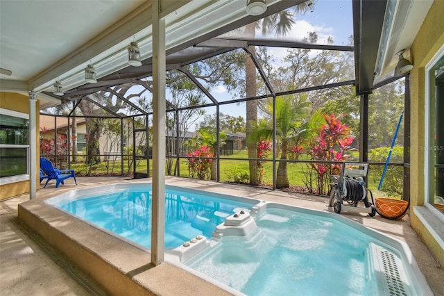 view of pool featuring a patio area, glass enclosure, and a hot tub