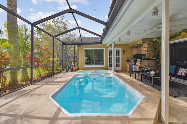 view of swimming pool with a lanai, a patio, and an outdoor kitchen